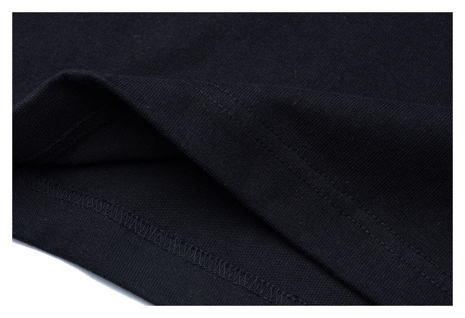 Close-up of the black shirt's folded bottom edge and overlocked seam.