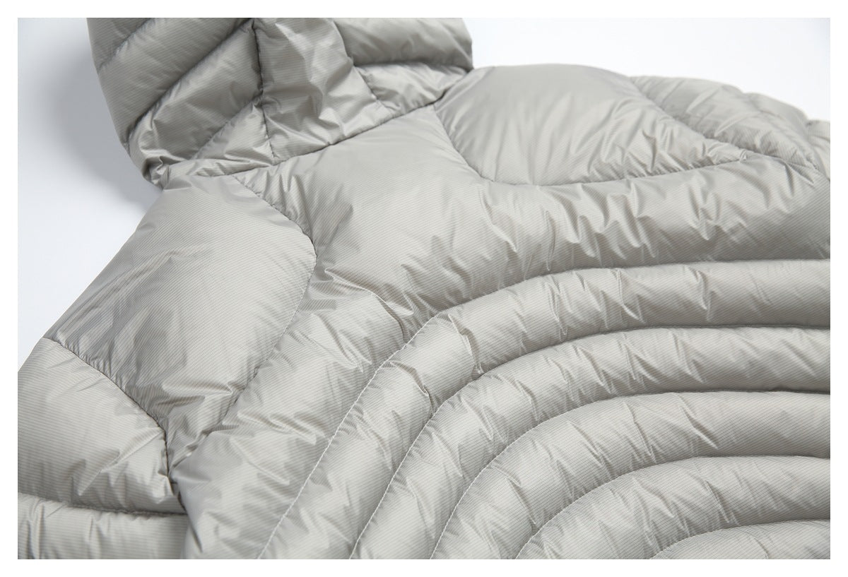 Close-up of the light gray pinstriped puffer jacket's curved quilted panels and stitching.