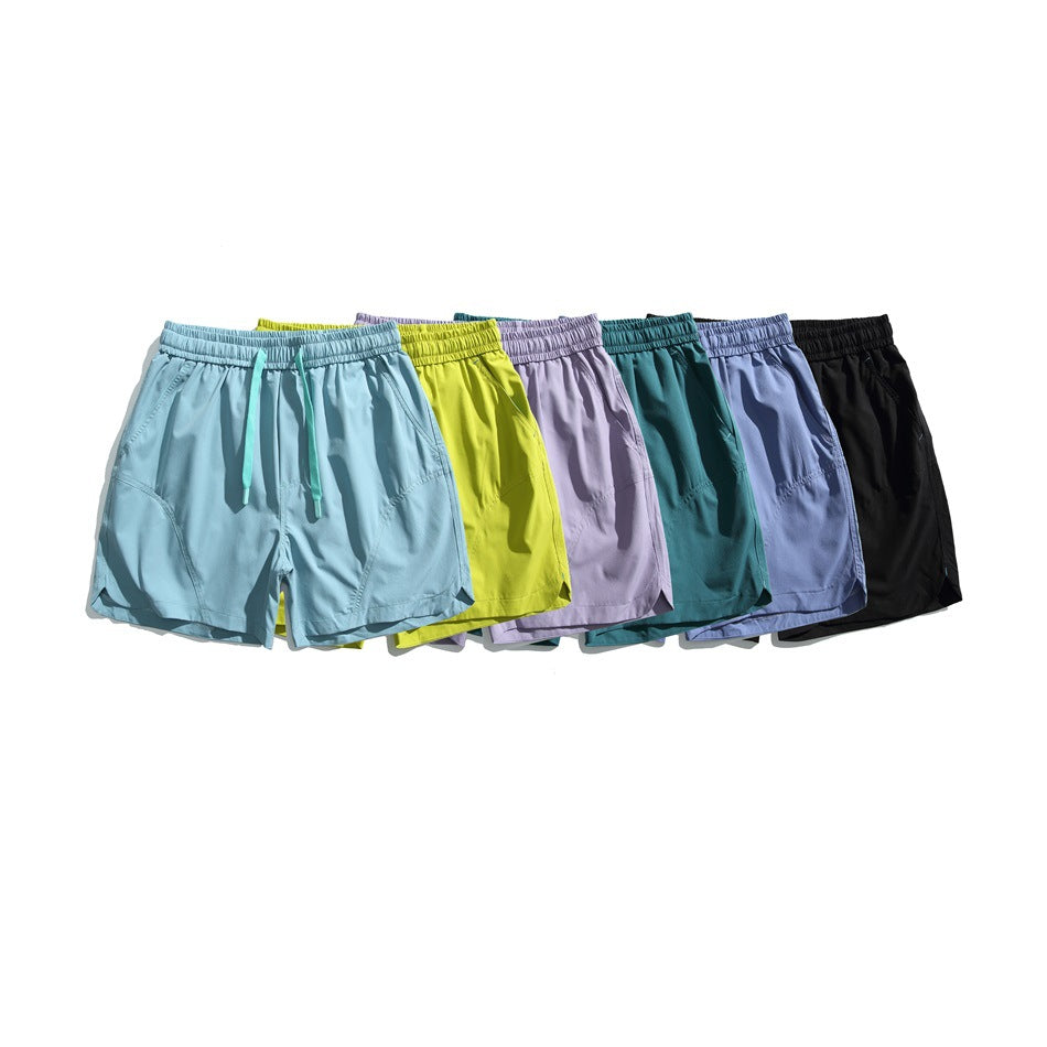Six pairs of drawstring shorts arranged together in light blue, lime, lavender, teal, periwinkle, and black.