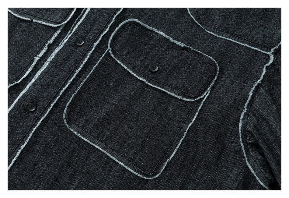 Close-up of a dark denim shirt front with a buttoned chest pocket and frayed pale edging.