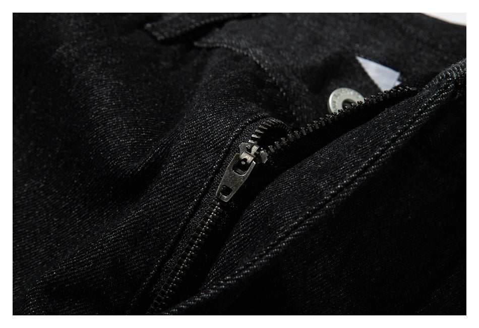 Close-up of the partially open metal zipper fly on black denim.