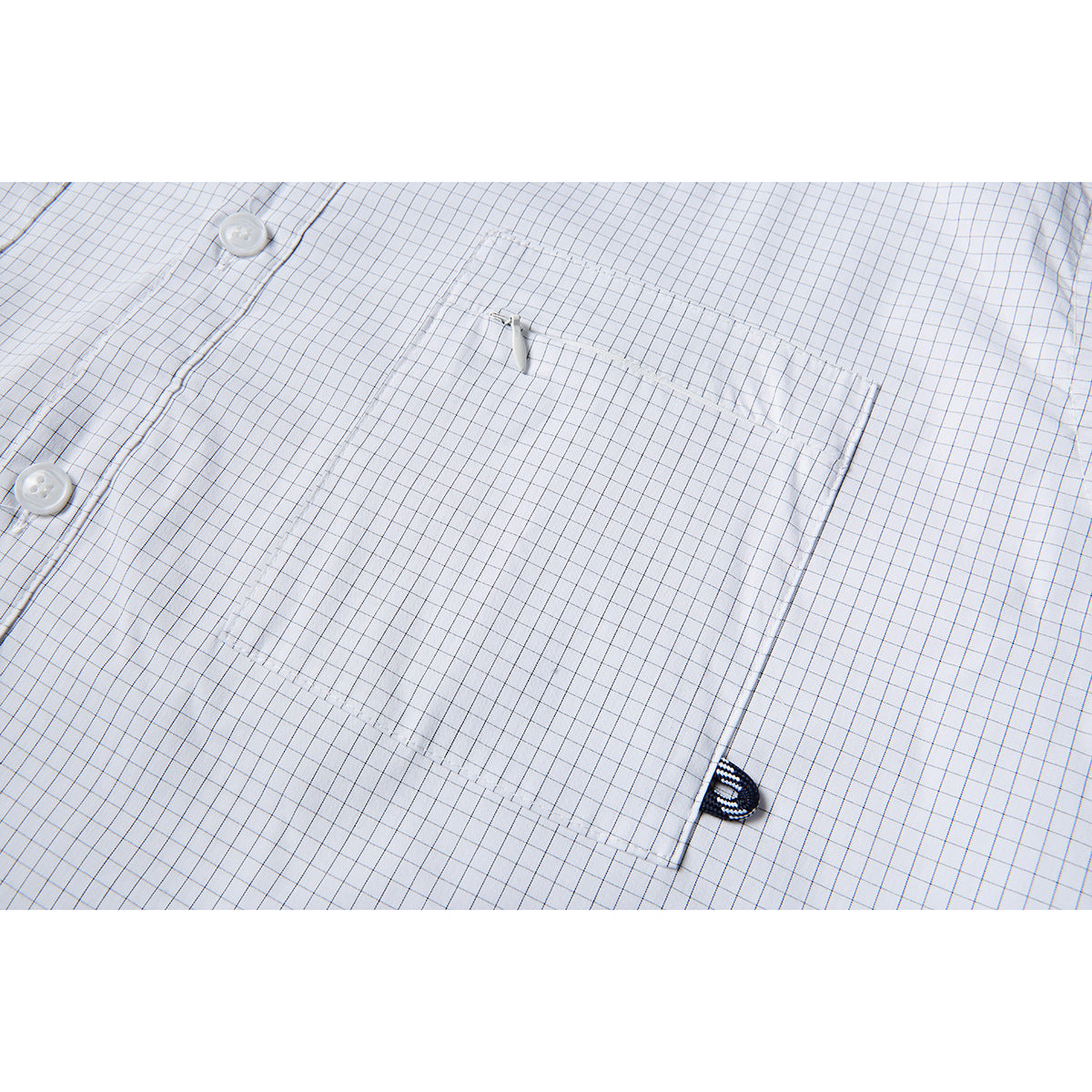 Close-up of a square chest pocket on a white shirt with a fine gray grid check.