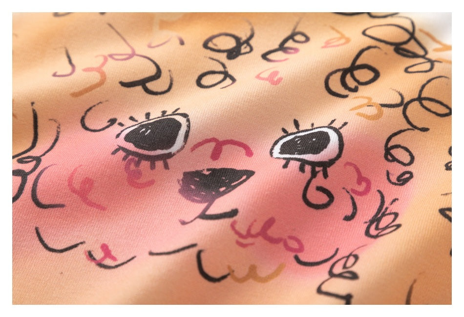 Close-up of the dog illustration's face, with black curls and pink and orange accents on white fabric.
