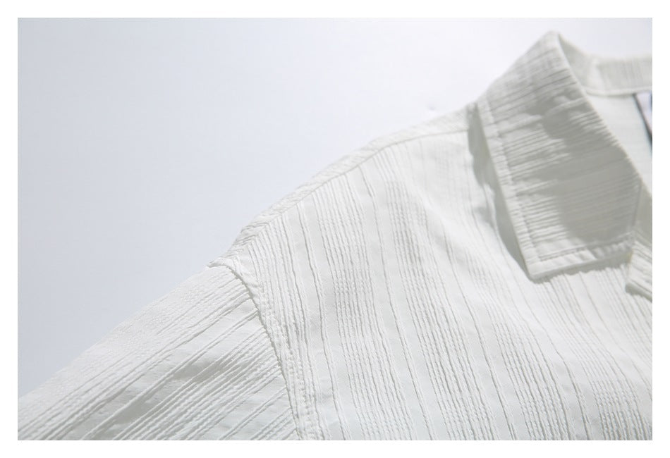Close-up of the white shirt's textured shoulder and pointed collar.