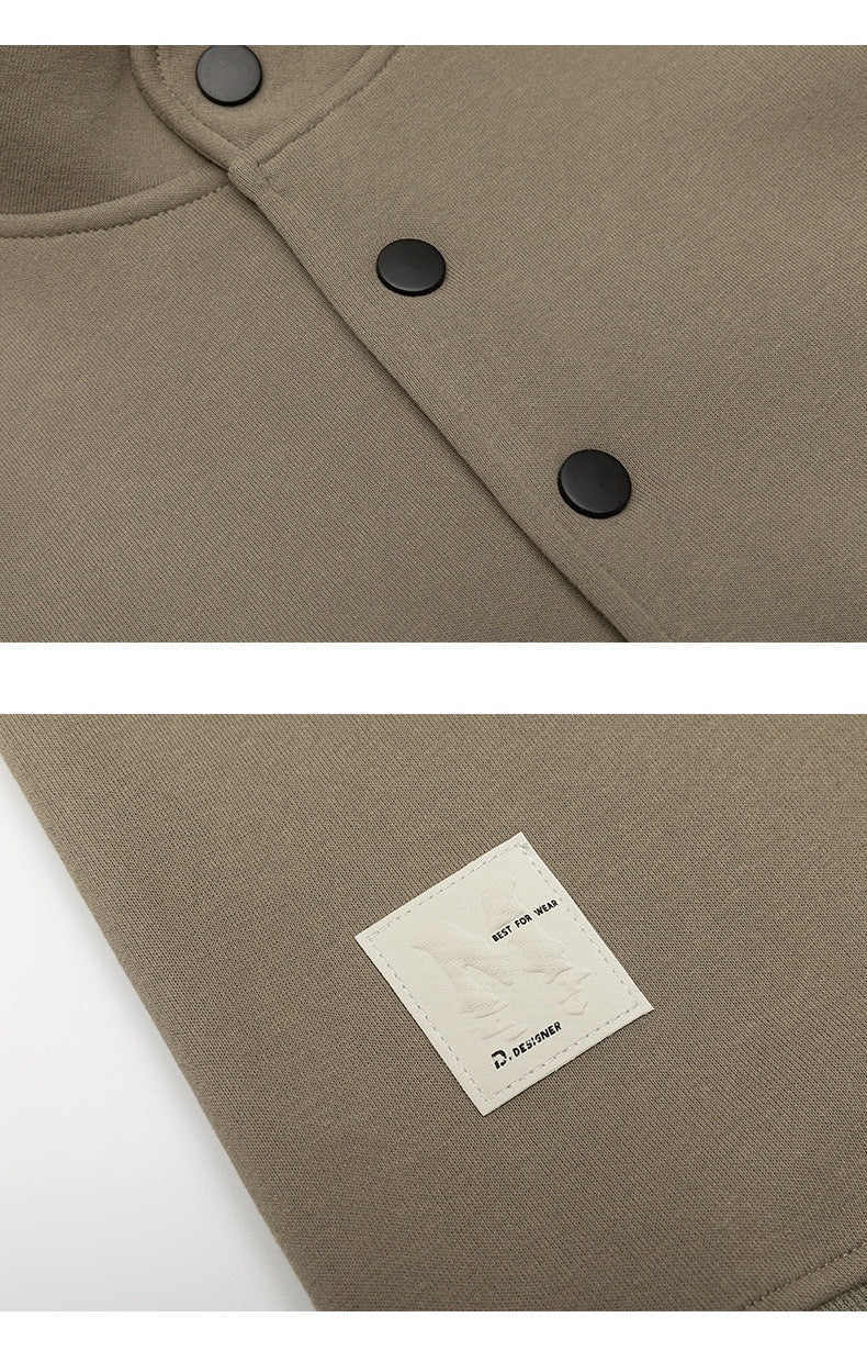 Close-up of taupe fabric with black snaps and a sewn cream label bearing small English text.
