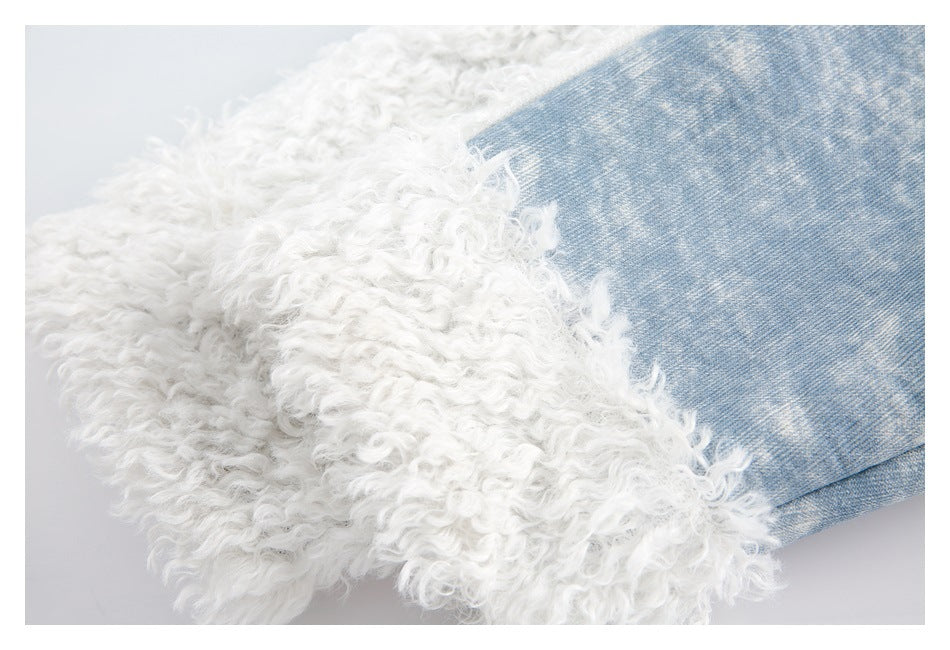 Close-up of white curly trim beside light blue denim on a jacket.