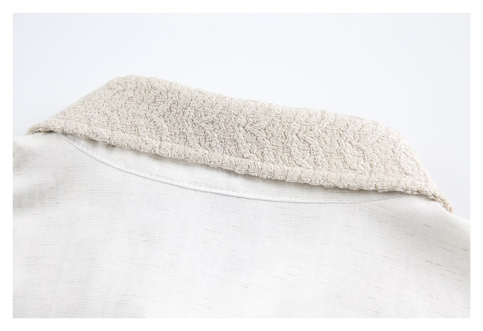 Close-up of an off-white garment collar, showing its textured underside and a seam along the neckline.