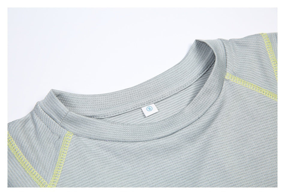 Close-up of the gray athletic top's crew neckline, textured fabric and yellow shoulder stitching.