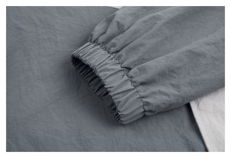 Close-up of a dark gray jacket sleeve ending in a gathered elastic cuff.
