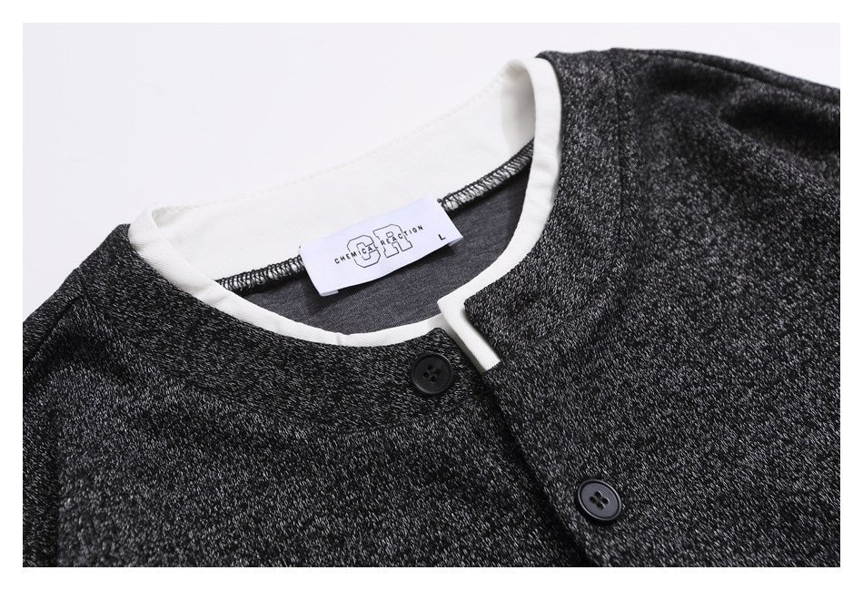 Close-up of a charcoal heather top showing its white-trimmed neckline, button placket, and neck label.