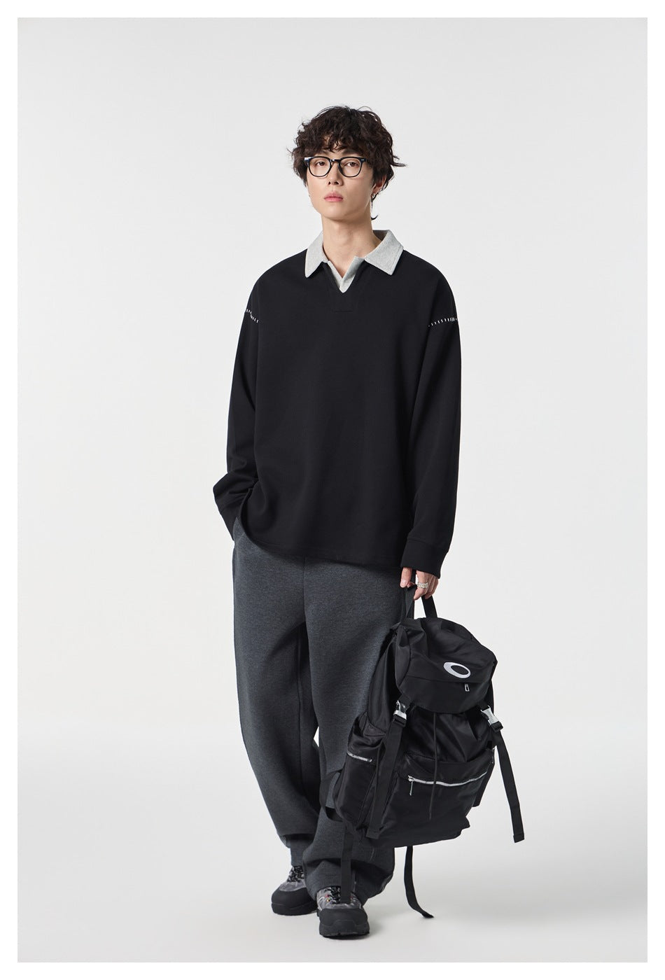Front view of a model wearing a black long-sleeve top with a light gray collar and shoulder stitching.