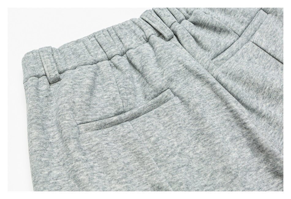 Close-up of heather gray pants showing an angled front pocket, waistband, and belt loops.