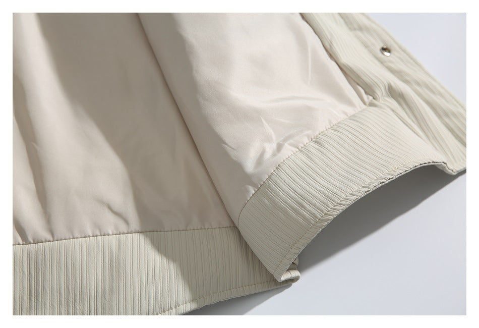 Close-up of a cream jacket sleeve cuff and ribbed lower hem.