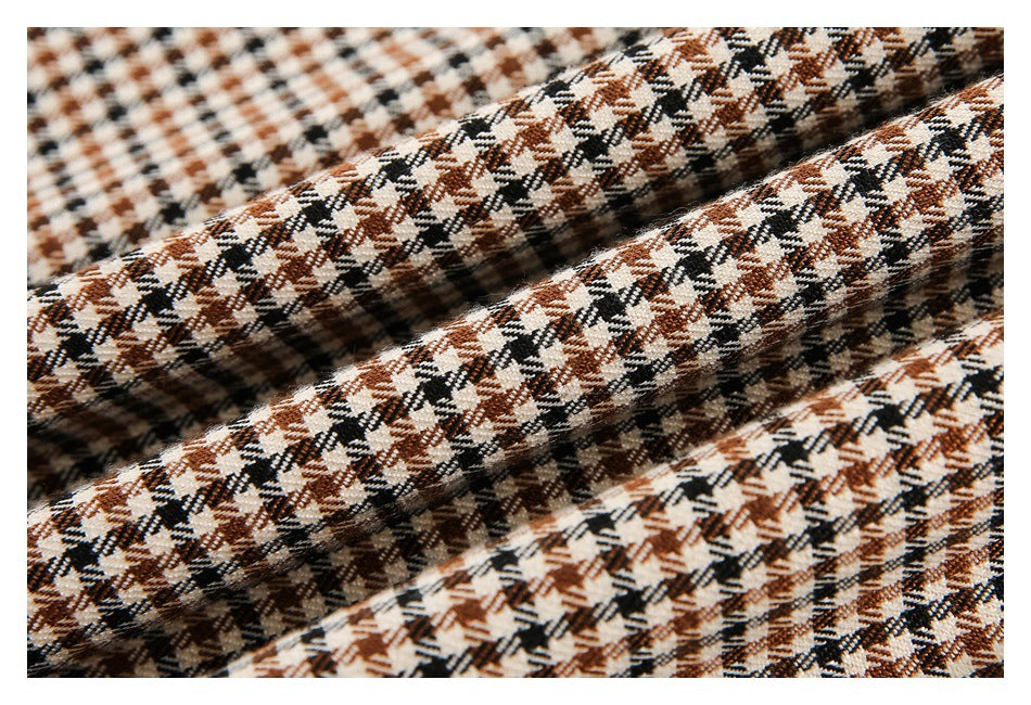 Close-up of brown, black, and cream check fabric arranged in soft folds.