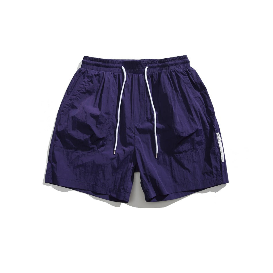 Purple drawstring shorts with white cord, front patch pockets and white side zipper tape, flat lay front view