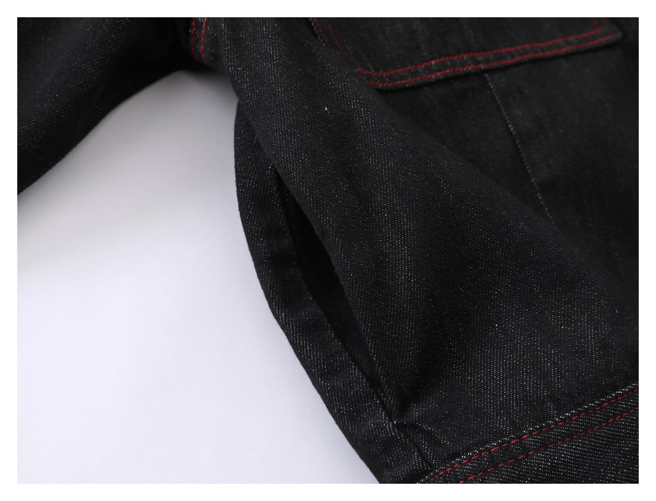 Close-up of black denim jacket fabric and seam stitching.