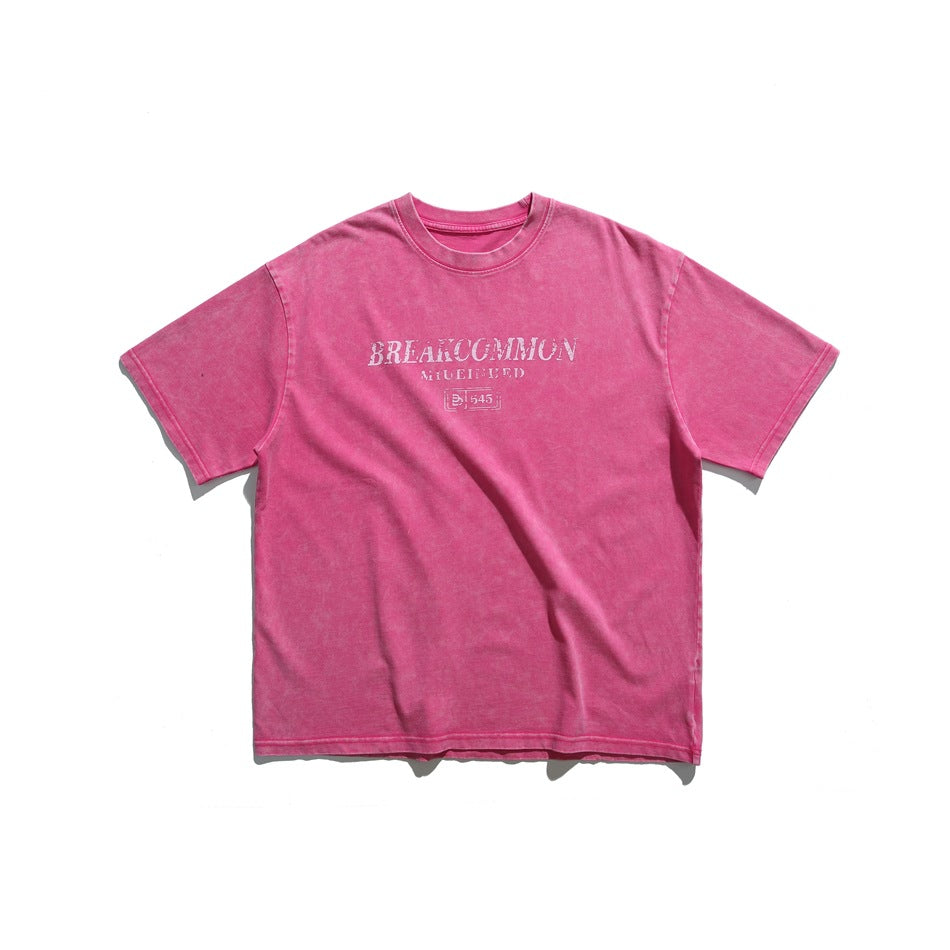 Pink washed-look short-sleeve crew-neck T-shirt with white distressed lettering graphic on the chest, flat lay