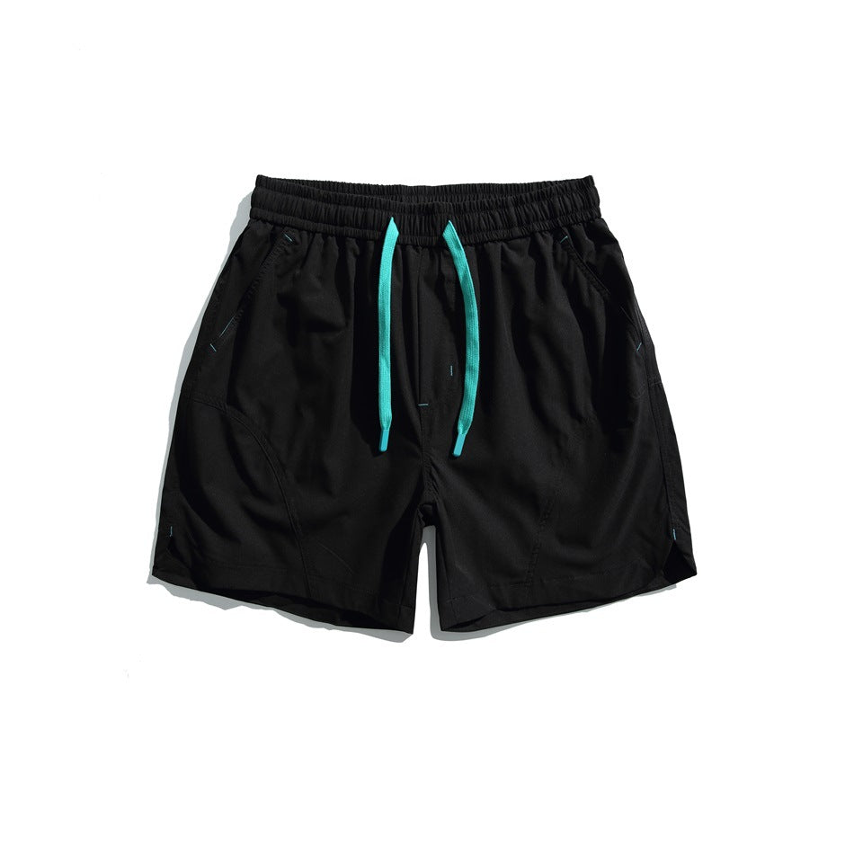 Black drawstring shorts with teal cords, curved leg seams and side pockets, flat lay front view