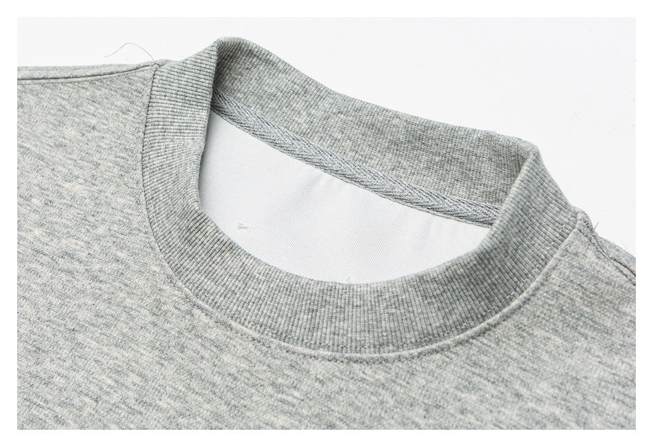 Close-up of the heather-gray sweatshirt's ribbed crew neckline and shoulder seam.