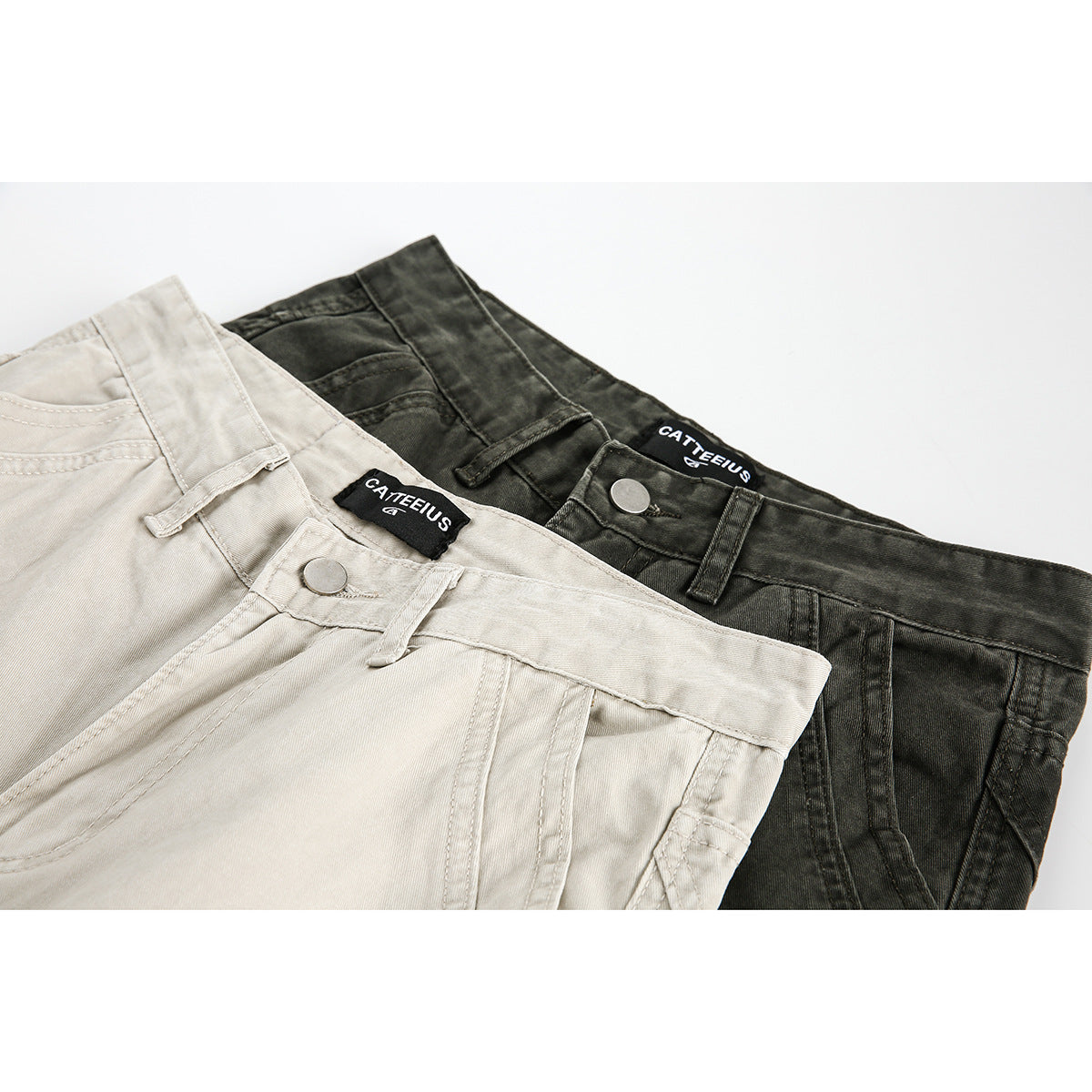 Close-up of light beige and dark charcoal cargo pants showing waistbands, buttons, belt loops, and brand labels.