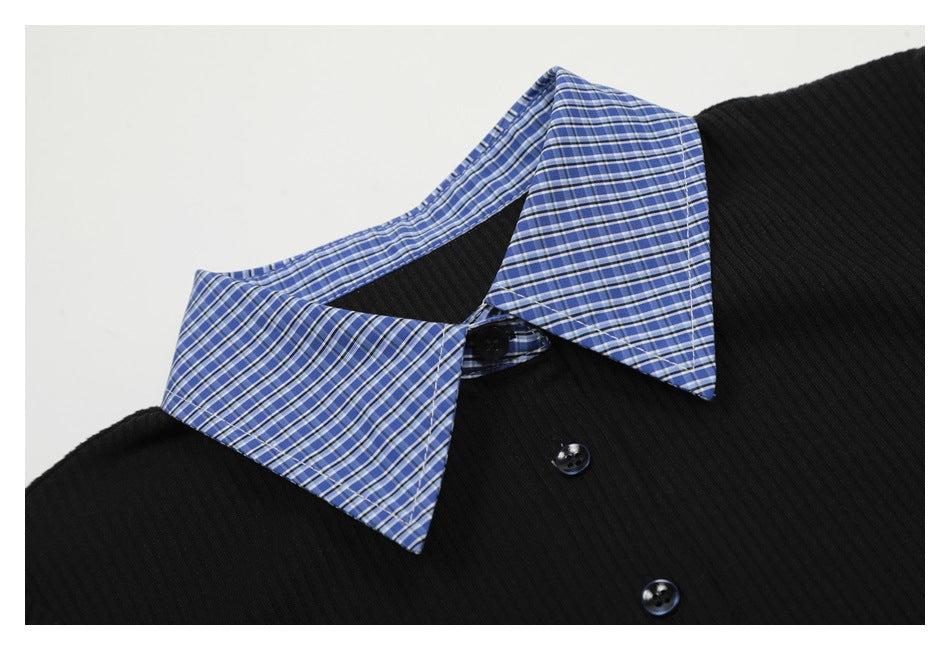 Close-up of a black ribbed collared top with a blue plaid collar and dark buttons.