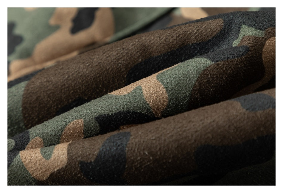 Macro view of the textured green, tan, black, and brown camouflage fabric.