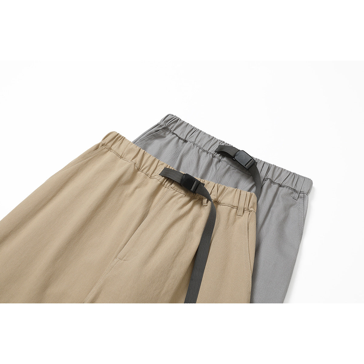 Close-up of tan and gray pants showing elastic waistbands, belt loops, and black buckle straps.