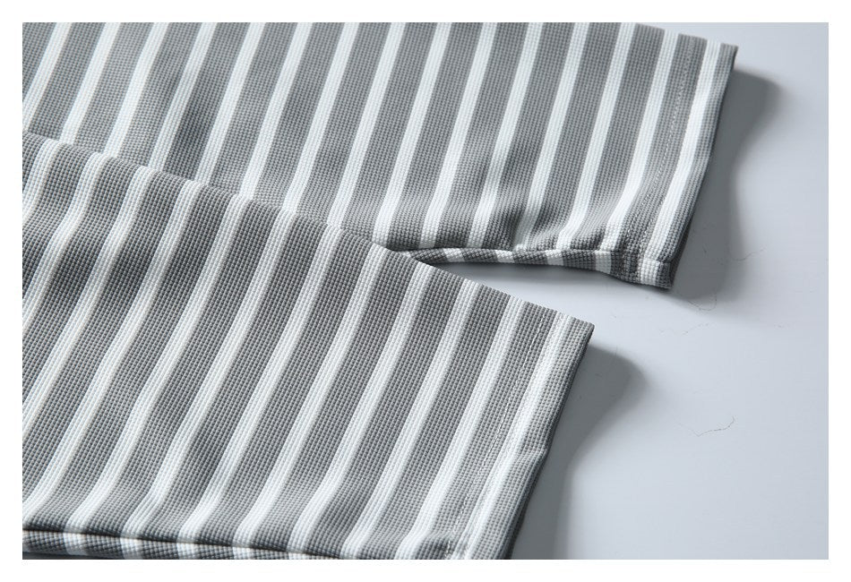 Close-up of gray-and-white striped garment edges with stitched hems laid flat.
