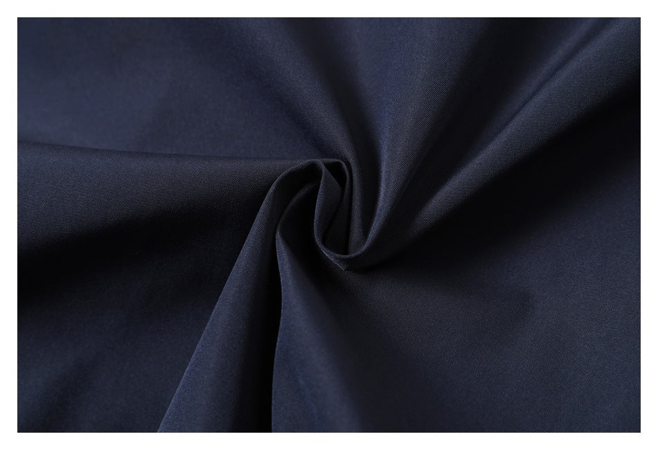Close-up of dark navy fabric gathered into a soft twist, showing its fine surface texture.