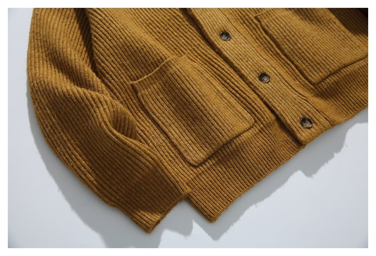 Close-up of the cardigan’s ribbed patch pocket, button placket, and lower hem.
