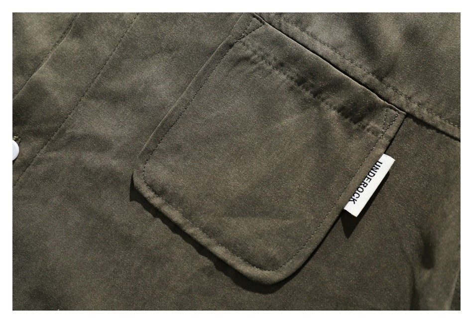 Close-up of an olive shirt's stitched chest pocket and small sewn side label.