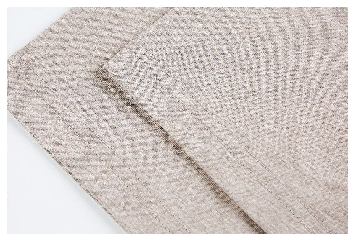 Close-up of the beige heather T-shirt fabric and parallel stitching along a seam.