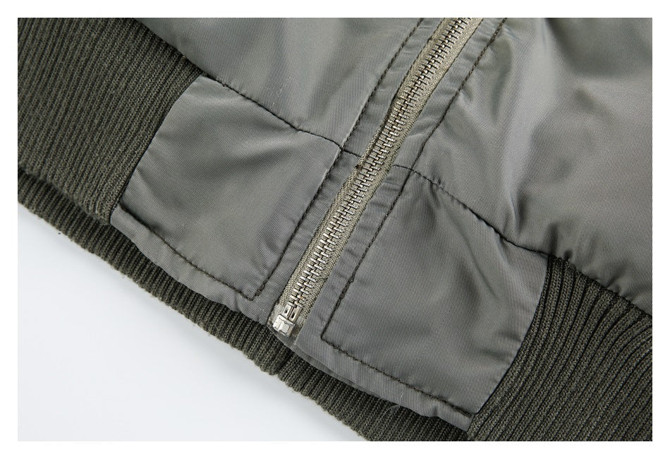 Close-up of the gray bomber jacket's front zipper, stitched panels, and ribbed hem.