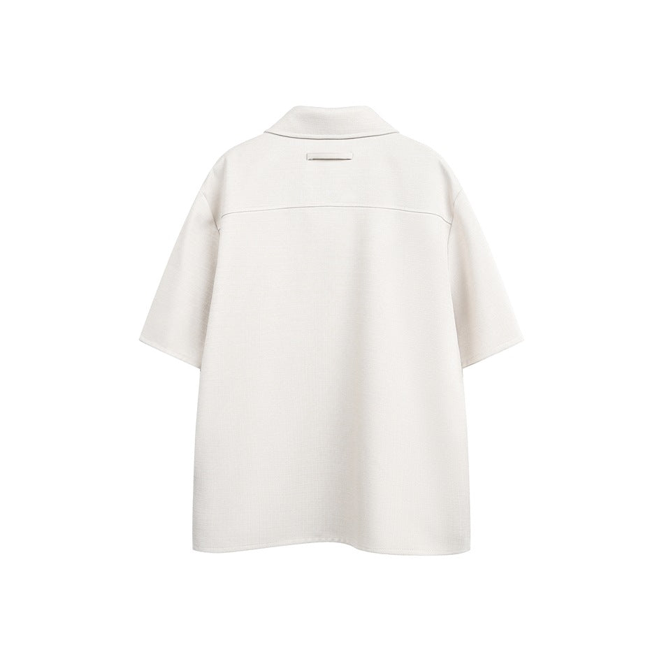 Back view of an off-white short-sleeve collared shirt with a horizontal back yoke seam.