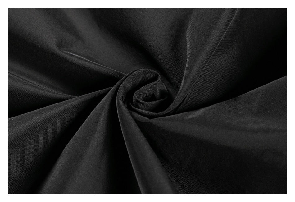 Close-up of black fabric gathered into soft folds to show its surface and drape.