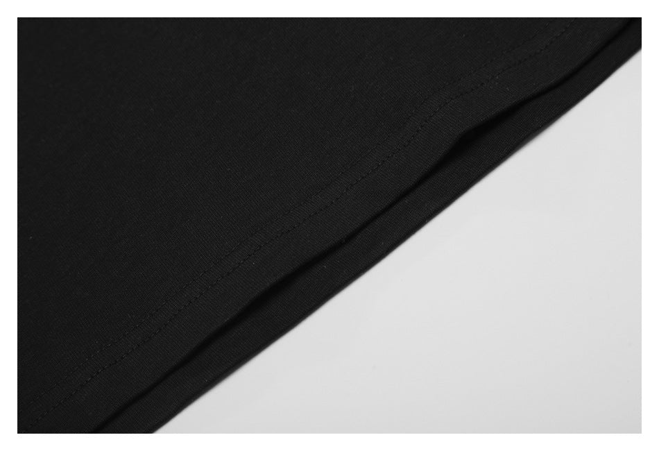 Close-up of black garment fabric and a neatly stitched curved hem against a light background.