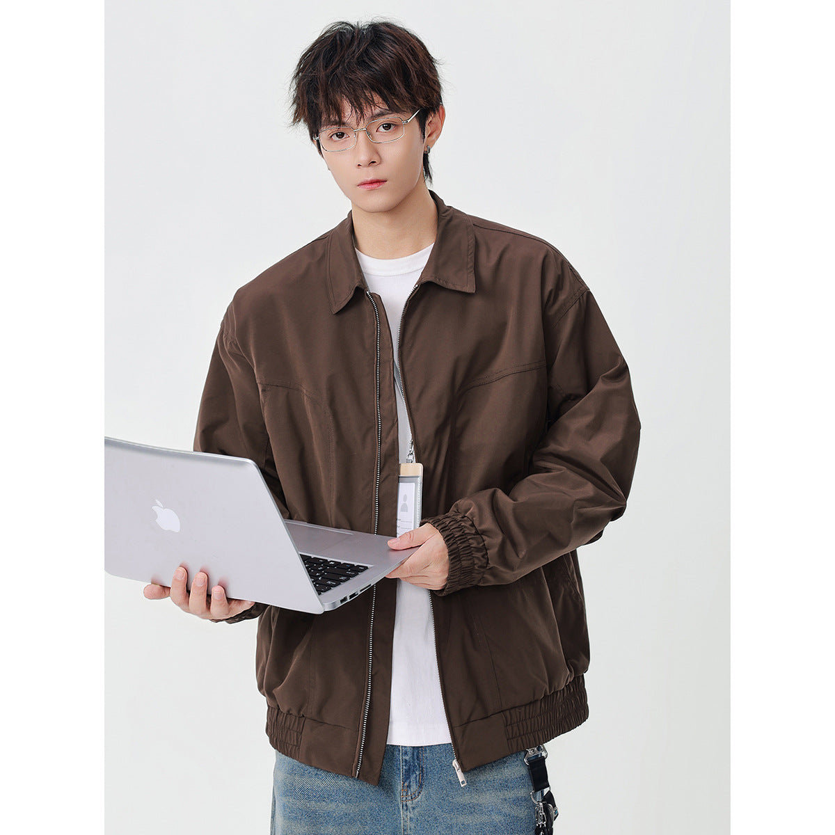 Model wearing a dark brown zip jacket with a pointed collar, elastic cuffs and hem, and front pockets.