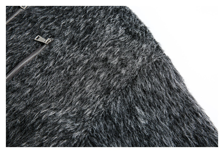 Close-up of the charcoal gray fuzzy jacket's sleeve and shoulder, with part of a silver zipper visible.