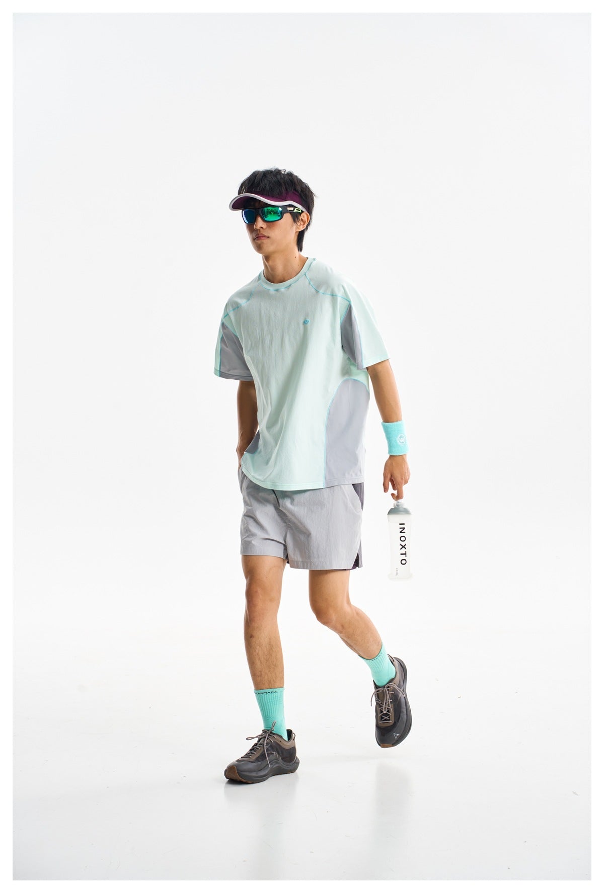 Model wearing a pale mint athletic T-shirt with gray contrast panels and gray shorts, shown from the front.