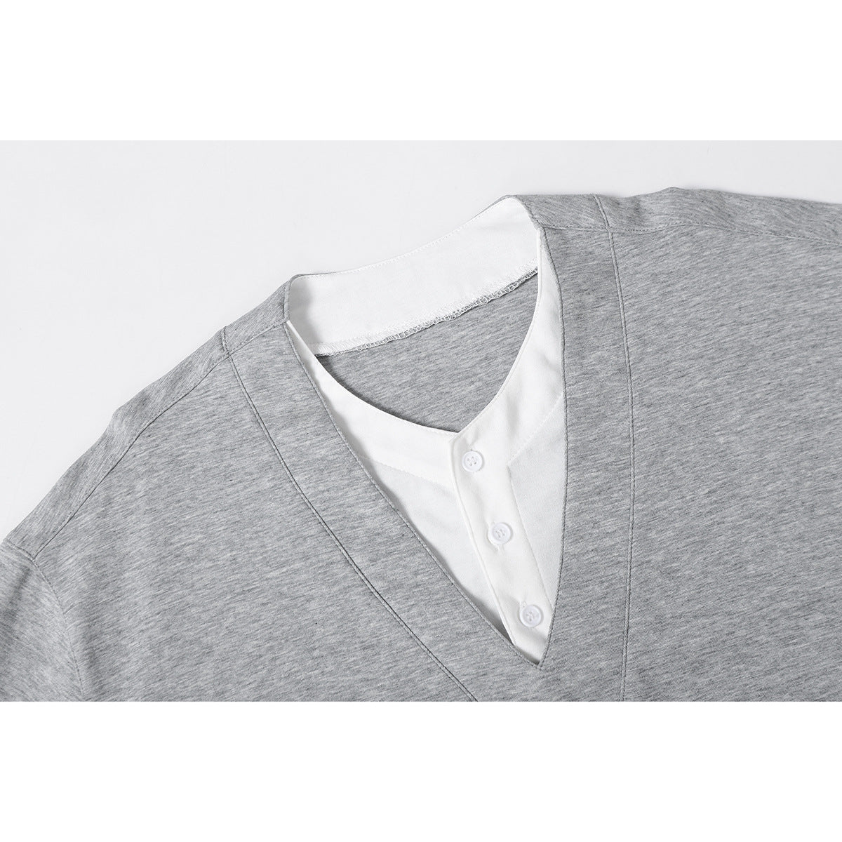 Close-up of a heather gray V-neck T-shirt with a white three-button placket insert.