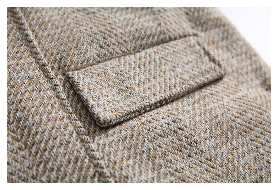 Close-up of a tan, cream and dark brown herringbone garment with a folded lapel.