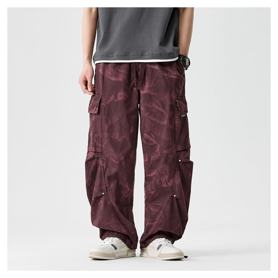 Cropped model shown from behind wearing loose burgundy cargo pants with large flap pockets and gathered ankles.