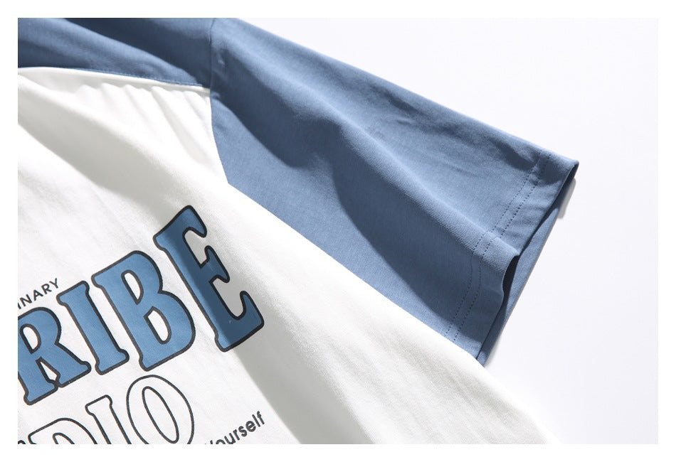 Close-up of a white T-shirt with a blue sleeve and part of a large blue-and-black chest print.