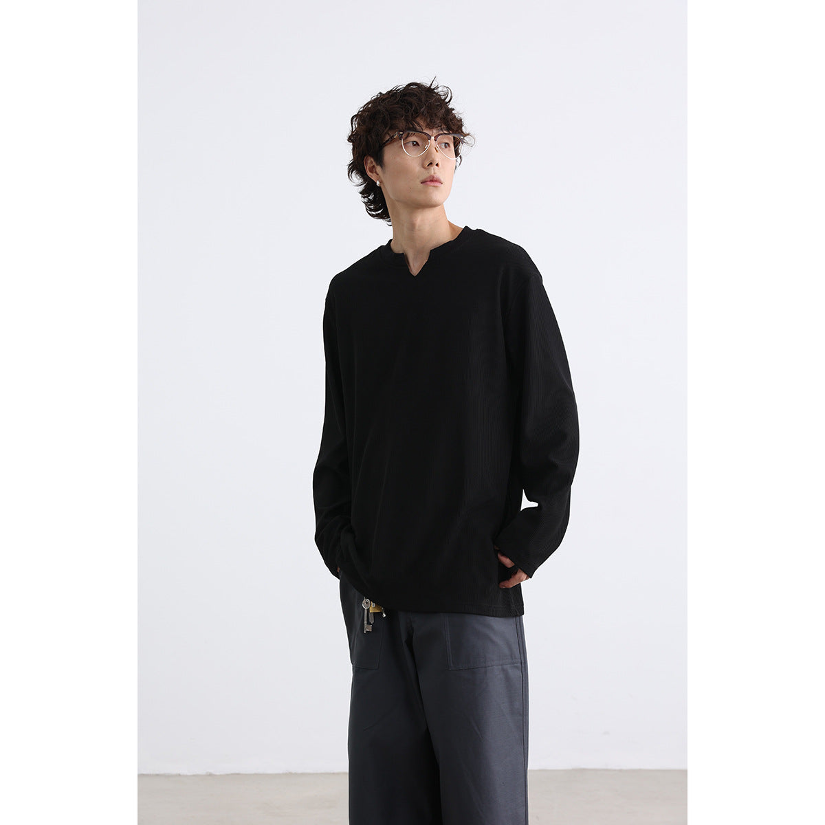 Closer view of a model wearing a black long-sleeve shirt with a notched neckline.
