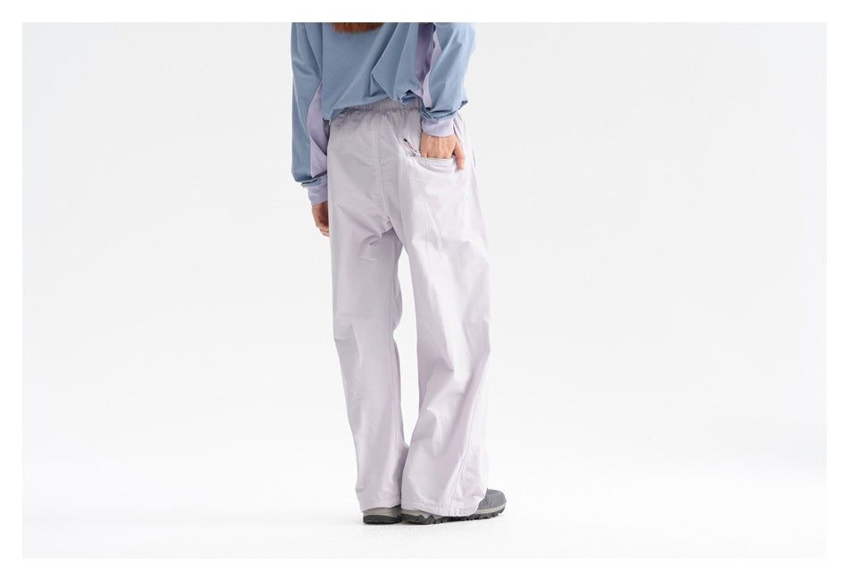 Back view of a model wearing pale lavender wide-leg pants with a rear pocket and light blue top.