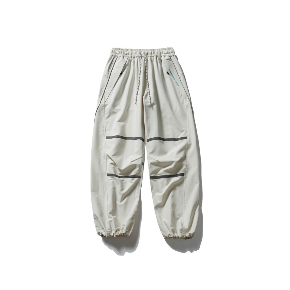 Off-white relaxed drawstring pants with dark gray stripes across the legs and gathered hems, laid flat