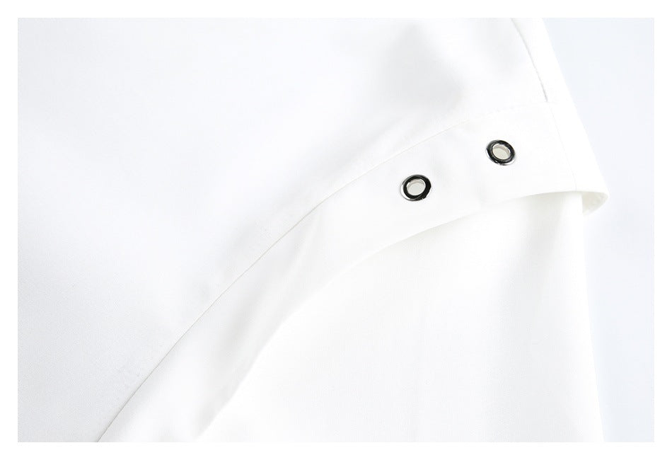 Close-up of white fabric with a folded edge and two dark metal eyelets.