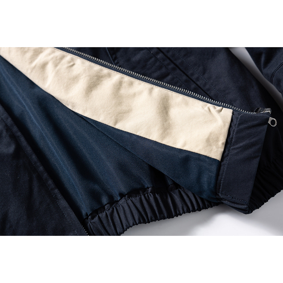 Close-up of the jacket's beige inner panel, zipper, and gathered elastic hem.