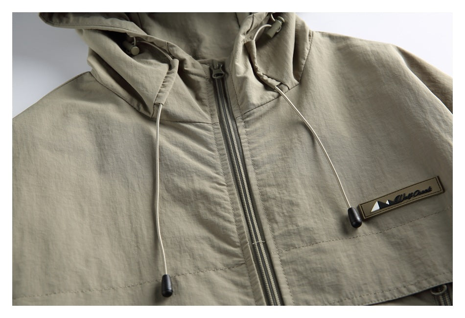 Close-up of the jacket’s hood drawcords, front zipper and sewn chest brand patch.