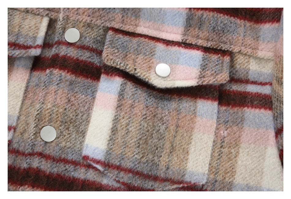 Close-up of a plaid coat with large flap pockets and round light-colored buttons.